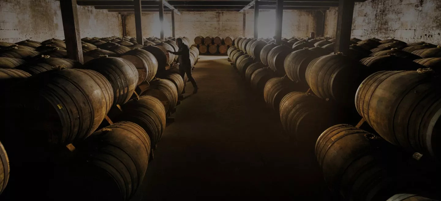 Casks of Courvoisier French cognac inspected by an employee.